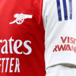 Arsenal players wearing jerseys with the "Visit Rwanda" logo, amid controversy over Rwanda’s alleged involvement in DRC conflict.