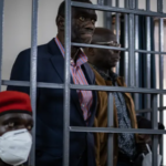 Opposition leader in court, appearing weak and unwell.