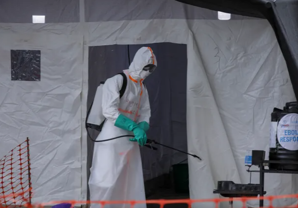 Ugandan health worker in protective gear addressing Ebola outbreak.