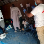 Healthcare workers in protective gear treating cholera patients in Ethiopia, highlighting the urgent need for medical aid and clean water access.