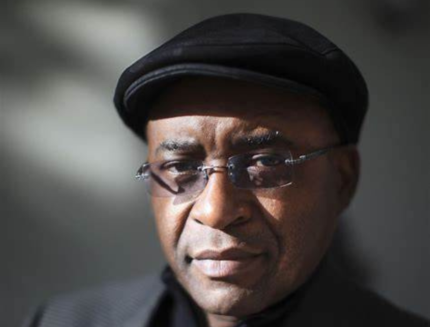 Strive Masiyiwa, African billionaire and founder of Econet Wireless, smiling in a business suit at a corporate event.