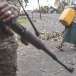 A disrupted trade route between East Africa and the Democratic Republic of Congo, showcasing halted trucks and affected traders.
