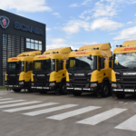 Modern Scania truck with DHL branding driving on a well-maintained road in East Africa, highlighting sustainability and logistics efficiency
