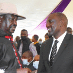 President William Ruto and opposition leader Raila Odinga shaking hands during a national event in Nairobi, symbolizing political unity in Kenya.