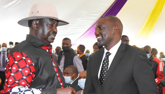 President William Ruto and opposition leader Raila Odinga shaking hands during a national event in Nairobi, symbolizing political unity in Kenya.