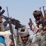 Armed fighters move through a conflict zone in Sudan as tensions and fighting escalate in El-Fasher.