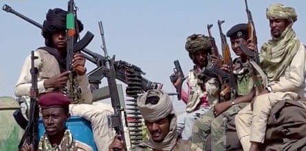 Armed fighters move through a conflict zone in Sudan as tensions and fighting escalate in El-Fasher.