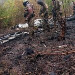Kenyan rescue officials and investigators inspect the wreckage of a small passenger plane that crashed in Kwale County while en route to Maasai Mara, killing 11 foreign tourists.