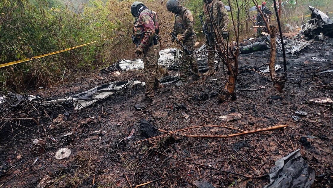 Kenyan rescue officials and investigators inspect the wreckage of a small passenger plane that crashed in Kwale County while en route to Maasai Mara, killing 11 foreign tourists.