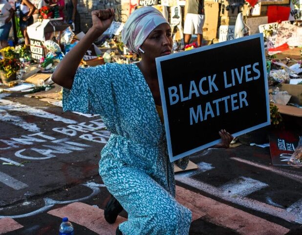 US President Donald Trump speaking at a public event, captured mid-speech against an official backdrop.