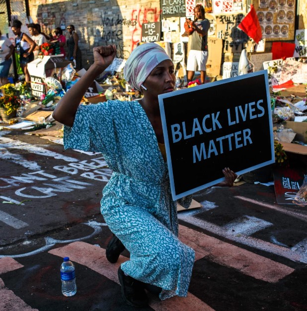 US President Donald Trump speaking at a public event, captured mid-speech against an official backdrop.