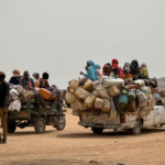 Displaced Sudanese women walk through the newly established El-Afadh camp in Northern State as UN officials warn of worsening humanitarian conditions.