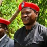 Kenyan activists Bob Njagi and Nicholas Oyoo raising their fists after returning to Nairobi following their secret detention in Uganda.