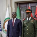 A police vehicle drives past burning tyres in Bissau during unrest following a reported military takeover.