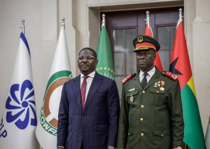 A police vehicle drives past burning tyres in Bissau during unrest following a reported military takeover.