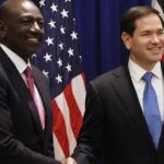 US Secretary of State Marco Rubio and Kenyan President William Ruto shake hands in Nairobi during the signing of a new Kenya–US health partnership, with both nations’ flags in the background.